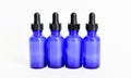 Four blue glass eyedropper bottles