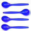 Four blue plastic teaspoons, one against the mainstream