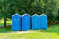 Four blue portable bio toilet on grass