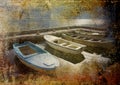 Four boats in stone harbour on grunge background