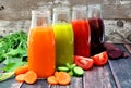 Four bottles of healthy vegetable juice with a rustic wood background