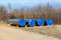 Four brand new large diameter pipes closed with nylon protection left at local oil pipeline construction site