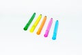 four bright colored pens lined up in a row on top of a table Royalty Free Stock Photo