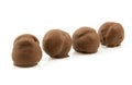 Four brown chocolate cream puffs in a row