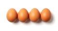 Four brown eggs aligned on a white surface, casting soft shadows, studio shot Royalty Free Stock Photo