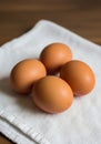 Four brown eggs are placed on a textured white cloth. The eggs have a smooth surface Royalty Free Stock Photo
