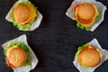 Four burgers with falafel, salad, onion rings, cheese and tomatoes on the black background. Classic american veggie fast food Royalty Free Stock Photo