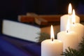 Four burning Advent candles with Bible and cross in background, religious symbol concept Royalty Free Stock Photo