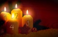 Four burning Advent candles with golden decoration and white snow. Royalty Free Stock Photo