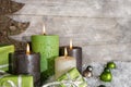 Four burning advent candles in green and brown on wooden background. Royalty Free Stock Photo