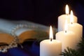 Four burning Advent candles with open Bible and rosary in background, religious symbol concept Royalty Free Stock Photo