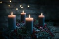 Four burning candles on an advent wreath with red Christmas decoration, tradition to bring light in the winter season, dark rustic Royalty Free Stock Photo