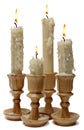 Four burning candles in wooden candlesticks