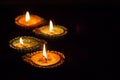 Four burning colorful clay diya lamp Diwali celebration. Black b