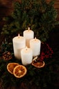 four burning white advent candles in advent wreath decoration on wooden dark background. Royalty Free Stock Photo