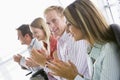 Four business people applauding indoors smiling