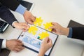 Four business people holding jigsaw puzzle and solving puzzle together. Royalty Free Stock Photo