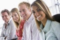 Four business people sitting indoors smiling