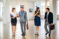 Four business people talking and walking in office lobby Royalty Free Stock Photo