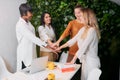 Four business women putting their hands together, happy teamwork Royalty Free Stock Photo