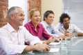 Four businesspeople in boardroom smiling