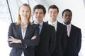 Four businesspeople standing in corridor smiling Royalty Free Stock Photo