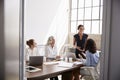 Four businesswomen in meeting, seen from doorway