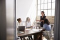 Four businesswomen in meeting, seen from doorway