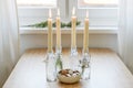 Four candles in bottles is lit for Advent, Christmas cookies and decoration on a table near the window, copy space, selected focus Royalty Free Stock Photo