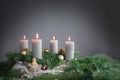 Four candles are burning for the fourth Advent on fir branches with Christmas decoration against a grey background, copy space Royalty Free Stock Photo