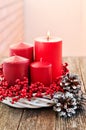 Four candles in a white wreath with red berries on a wooden rustic background with lights. advent calendar for Christmas Royalty Free Stock Photo