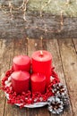 Four candles in a white wreath with red berries on a wooden rustic background with lights. advent calendar for Christmas Royalty Free Stock Photo