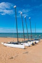 Four catamarans laid on the sand by the sea