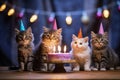 Four cats celebrating a birthday with cake.