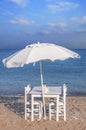 Four chair and umbrella with wooden table on beach and blue sea Royalty Free Stock Photo