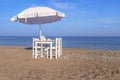 Four chair and umbrella with wooden table on beach and blue sea Royalty Free Stock Photo