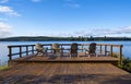 Four Chairs on a Wooden Deck with a View of a Lake Royalty Free Stock Photo