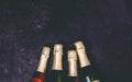 Four champagne bottles on dark background, flat lay Royalty Free Stock Photo