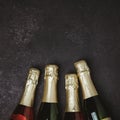 Four champagne bottles on dark background, flat lay Royalty Free Stock Photo