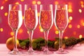 Four champagne glasses against pink background with blurred garland Royalty Free Stock Photo