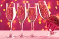 Four champagne glasses against pink background with blurred garland Royalty Free Stock Photo