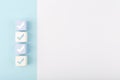 Checkmarks on four light toy blocks against white background with copy space