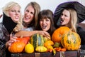 Four cheerful women celebrating Halloween together during costum