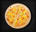 Four cheese pizza on a black background.