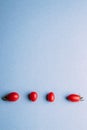 Four cherry tomatoes on a blue background, space for text Royalty Free Stock Photo