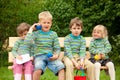 Four chi on bench in park. In identical shirts Royalty Free Stock Photo