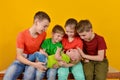 Four children hold a small child in their arms, happy and joyful brothers and sisters