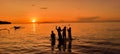 four children playing on the beach while sunset Royalty Free Stock Photo