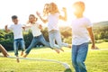 Four children sit on green grass on the ground and eat donuts and smile, sweet food, good friendship.