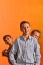 Four children stand in a row on a yellow background, the younger ones look out for the older ones Royalty Free Stock Photo